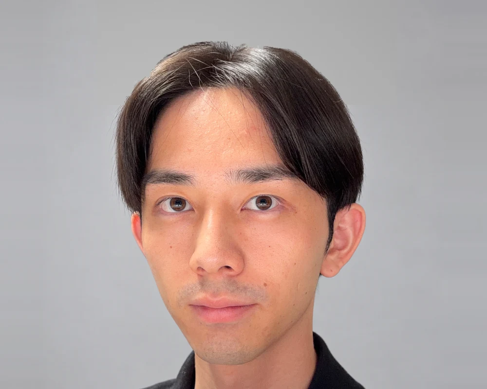 Takeki Tomonari of Startup Junkie Consulting, in a black polo against a light gray background